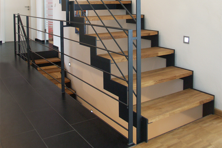 Zigzag-Treppe aus Stahl mit Stufen aus Holz in einem Neubau.