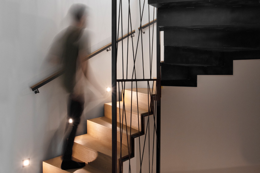 gewendelte Faltwerktreppe aus Stahl und Holz mit Geländerharfe