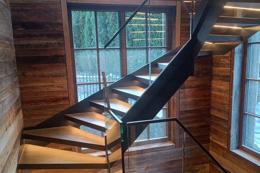 gewendelte Wangentreppe aus Stahl, Glas und Holz