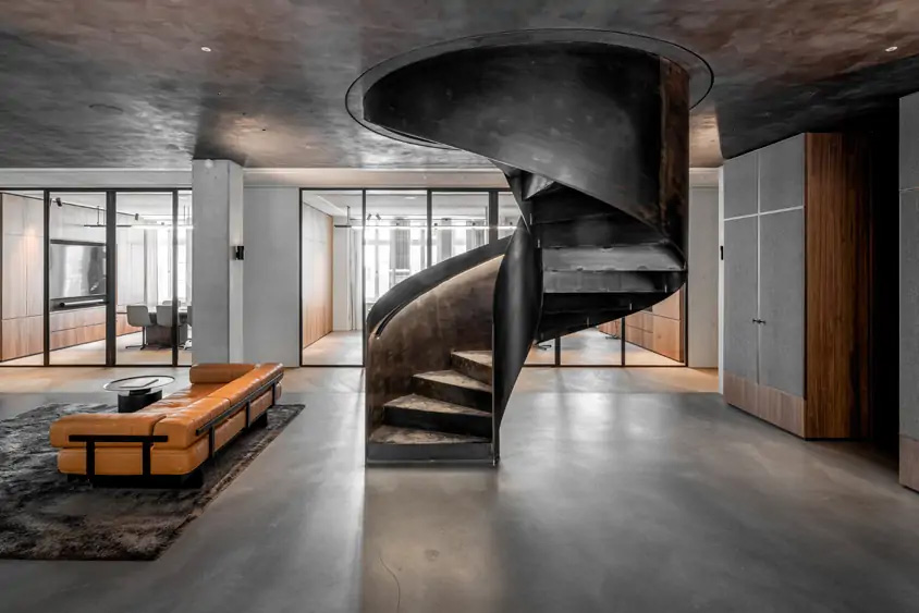 Spindeltreppe aus Stahl mit beleuchtetem Handlauf als Geschäftstreppe in einem Bürogebäude