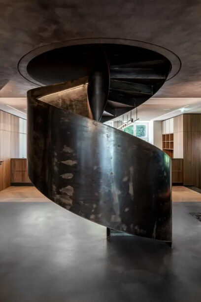 Spindeltreppe aus Stahl mit beleuchtetem Handlauf als Geschäftstreppe in einem Bürogebäude