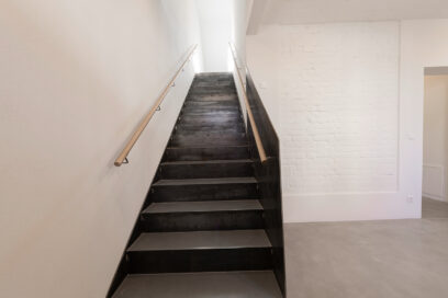 Treppe im Bauen im Bestand - gerade Faltwerktreppe aus Stahl mit geschlossenem Geländer