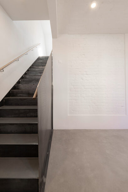 Treppe im Bauen im Bestand - gerade Faltwerktreppe aus Stahl mit geschlossenem Geländer
