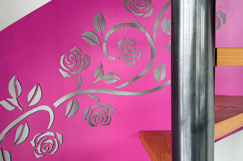 Spindeltreppe in pink mit Ornamentgeländer